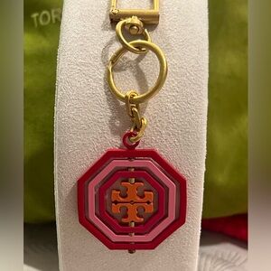 Tory Burch Rotating Geo Key Fob/bag charm in red and pink hues.